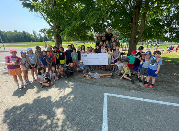 The Queen Elizabeth Public School students hold cheque.